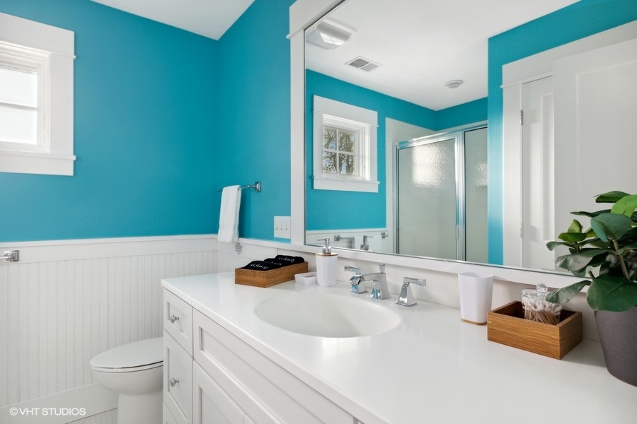 Blue walls and white fixtures make for a calming bathroom oasis.