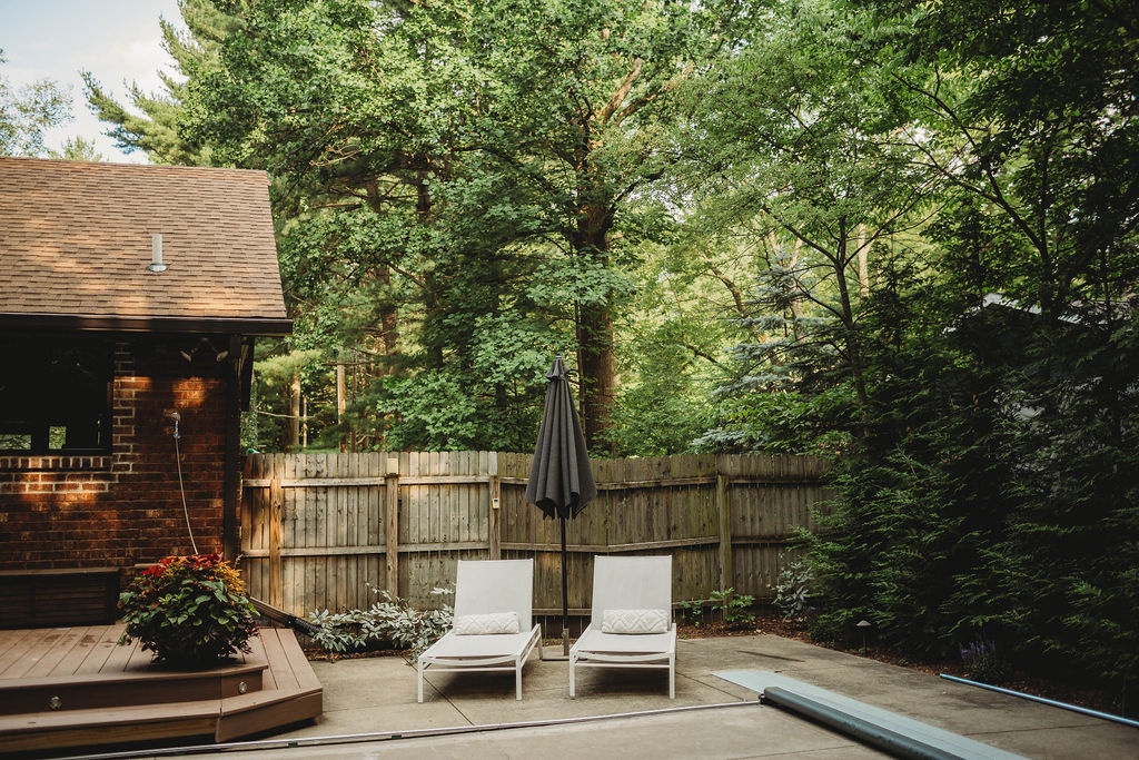 A serene lounging spot tucked into the home’s lush woodland setting.