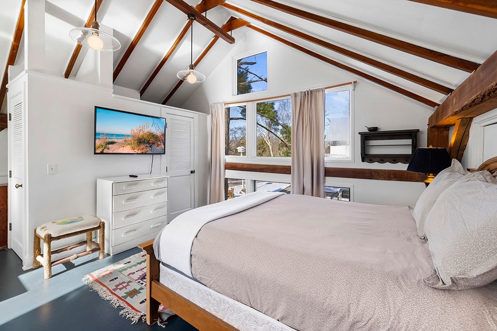 Wake to gentle light and treetop views at The Loft's tranquil sleeping space.