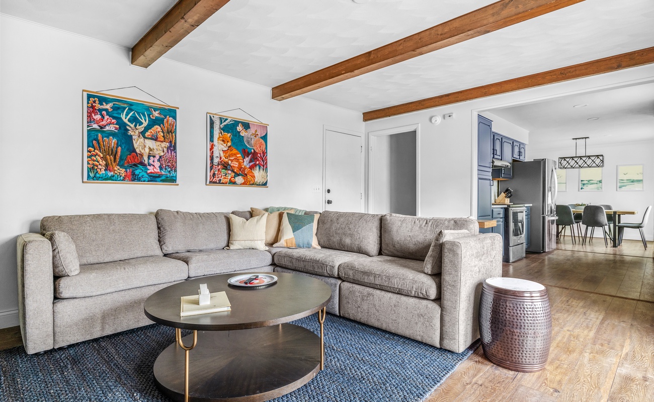 Kick back in this chic retreat with comfy seating, warm wood accents, and room for everyone to relax.