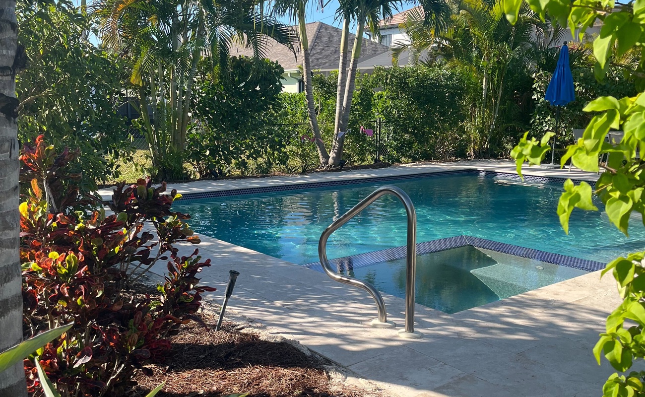 Dive into your own tropical oasis surrounded by lush palms and vibrant greenery.