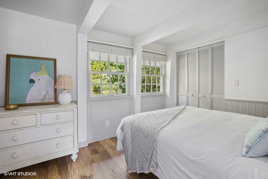 Embracing the minimalist aesthetic in my white bed and wooden floor bedroom.