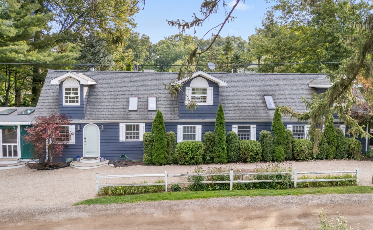 Embracing the tranquility of my charming blue house amidst a backdrop of greenery.
