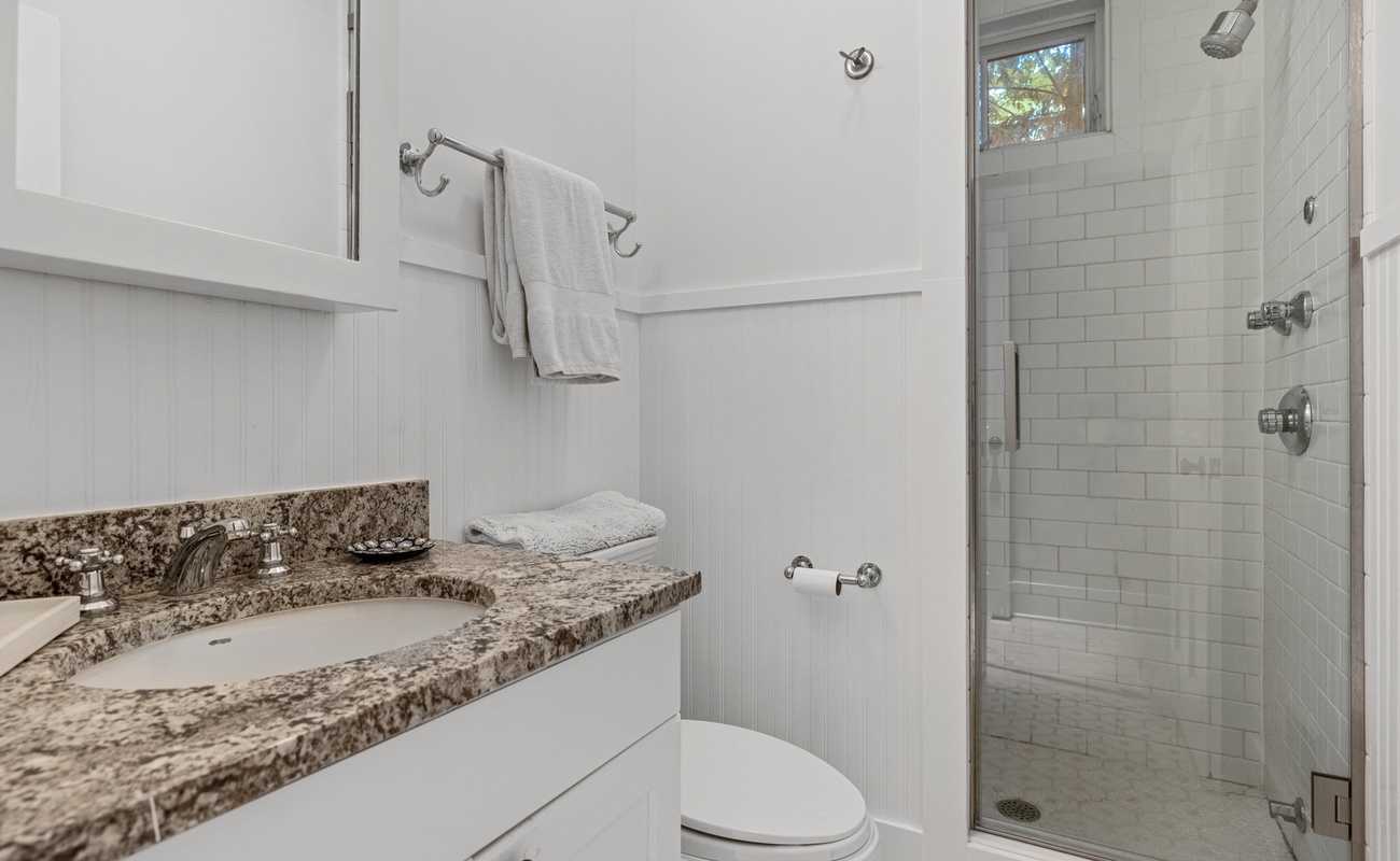 Transform your bathroom into a sanctuary with white cabinets and a luxurious shower stall.