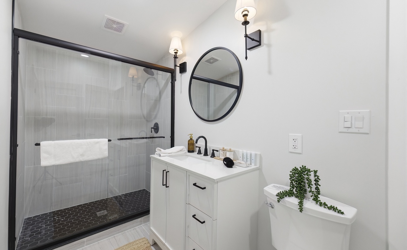 Modern black accents and a bright vanity create a crisp, clean retreat.