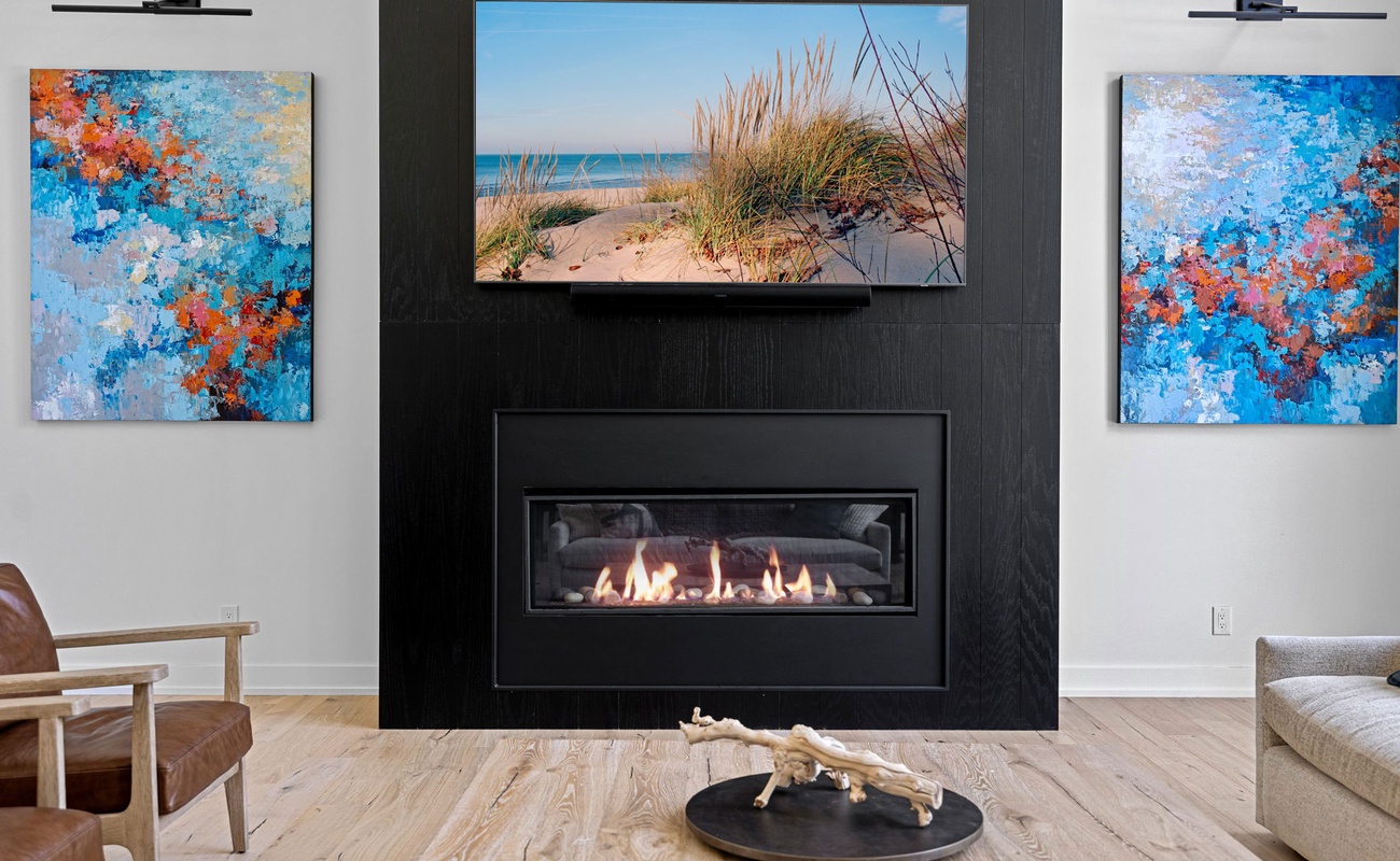 Ignite your creativity in this contemporary living room adorned with beautiful artwork and a warm fireplace.