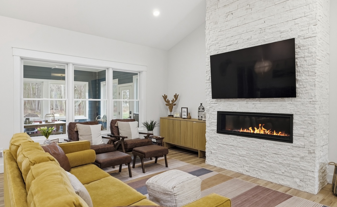 Living room area with gas fireplace, comfortable seating and smart TV.