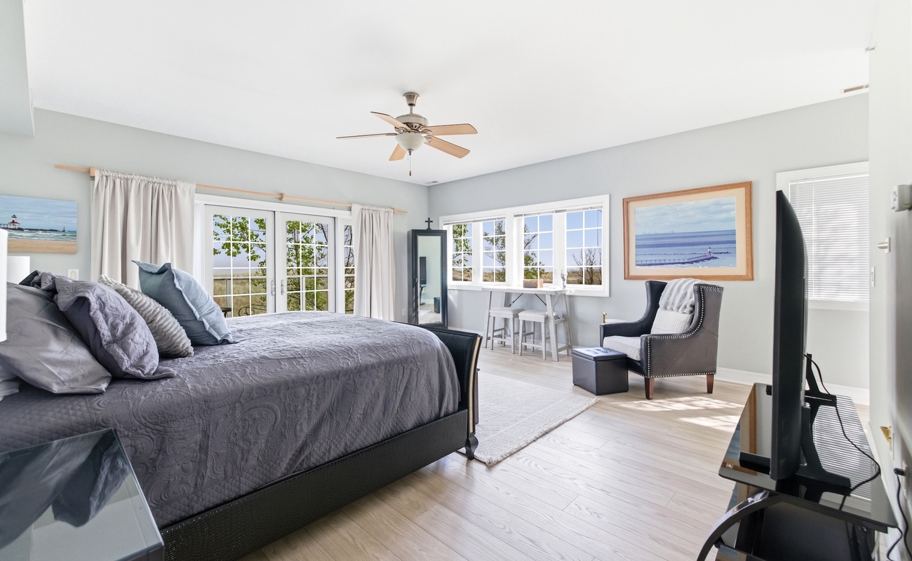 Large primary bedroom retreat featuring a private balcony and scenic views