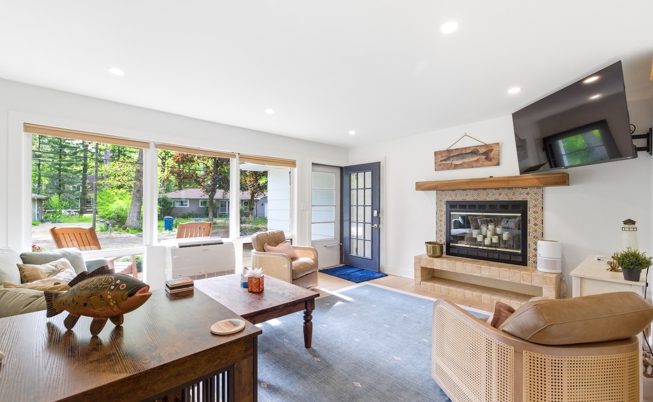 Bright and welcoming living room with fireplace and large windows letting in natural light