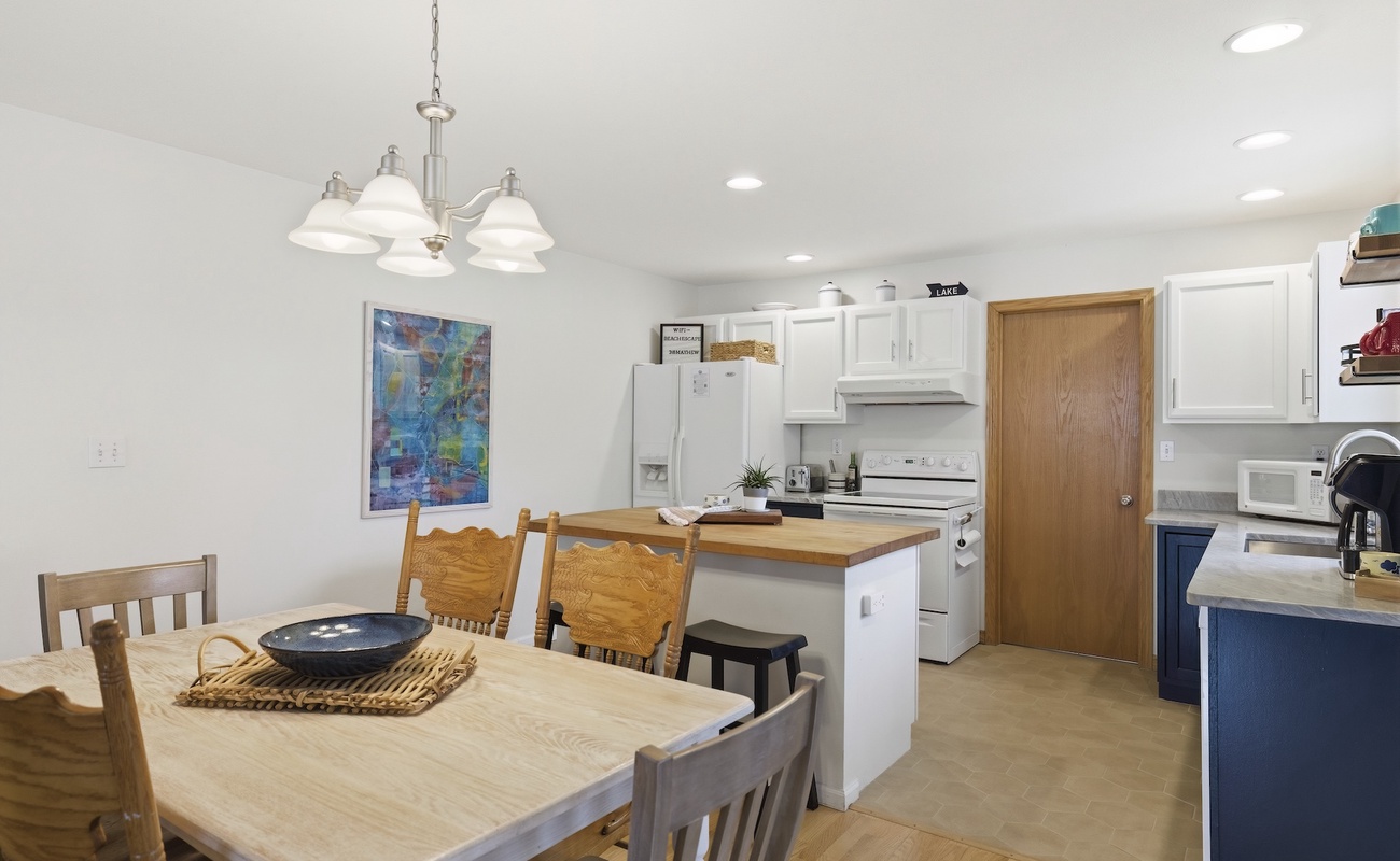 This bright, updated kitchen features white cabinetry and new quartz countertops