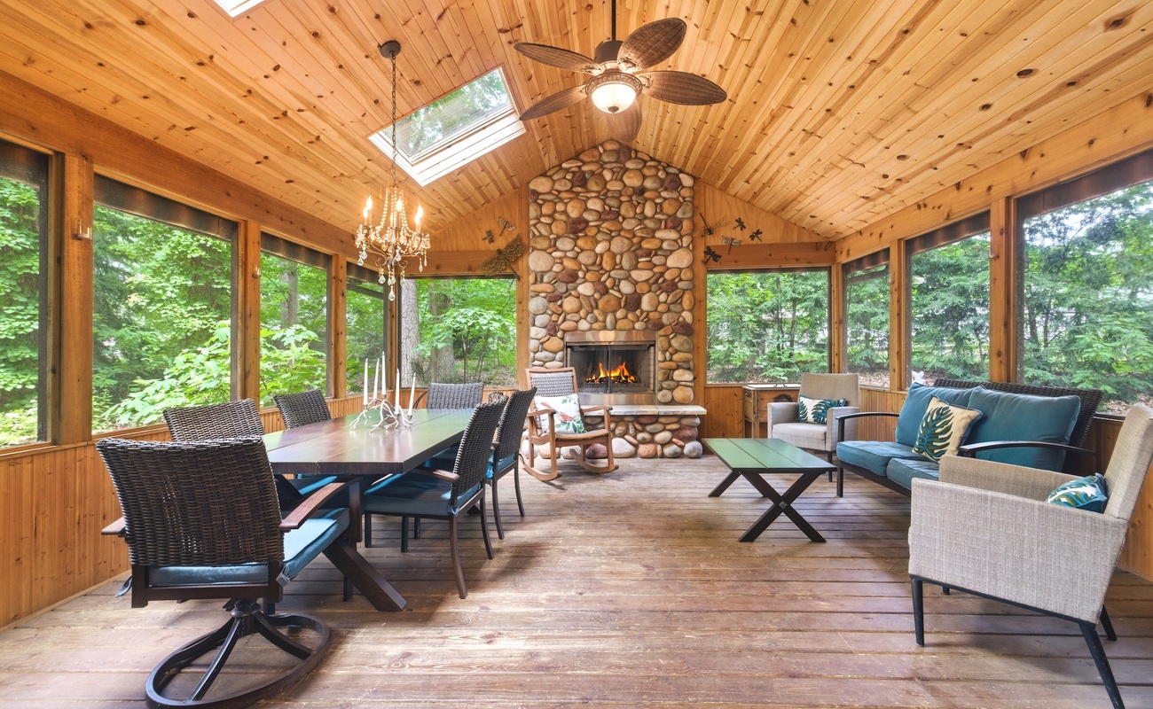 Spacious screened porch with a stone fireplace.