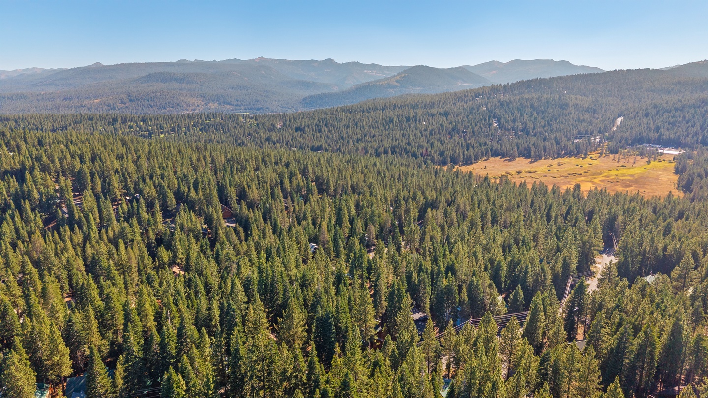 Expansive forested landscape with mountain ranges in the distance, showcasing the natural beauty of the surrounding area.