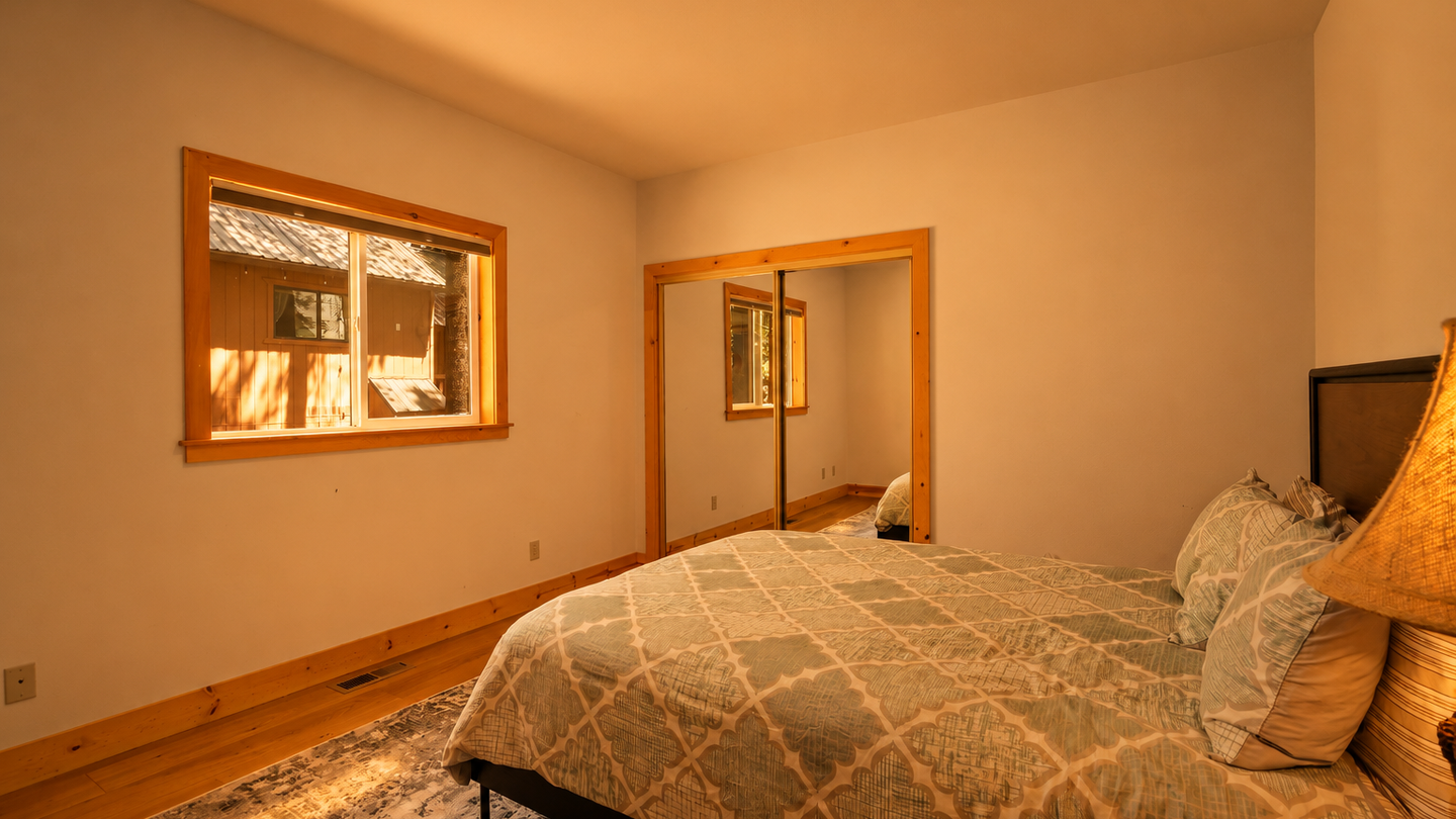 Your peaceful bedroom awaits with warm wood accents and natural light filtering through the window. Drift off surrounded by clean lines, cozy textiles, and a view into the next room.