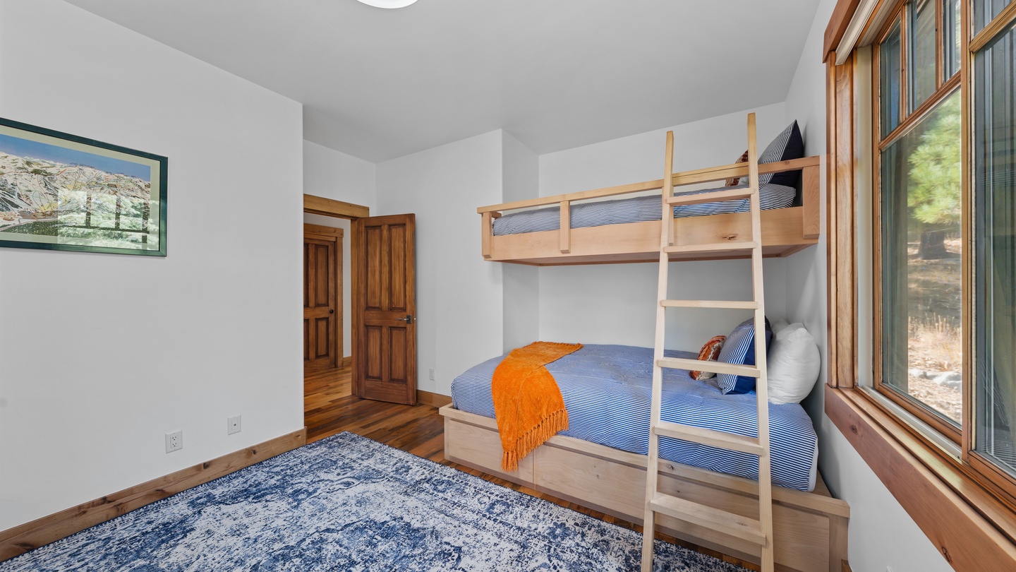 Your kids will love calling dibs on the top bunk in this cheerful bedroom, where warm wood tones and natural light create a cozy mountain retreat just for them.