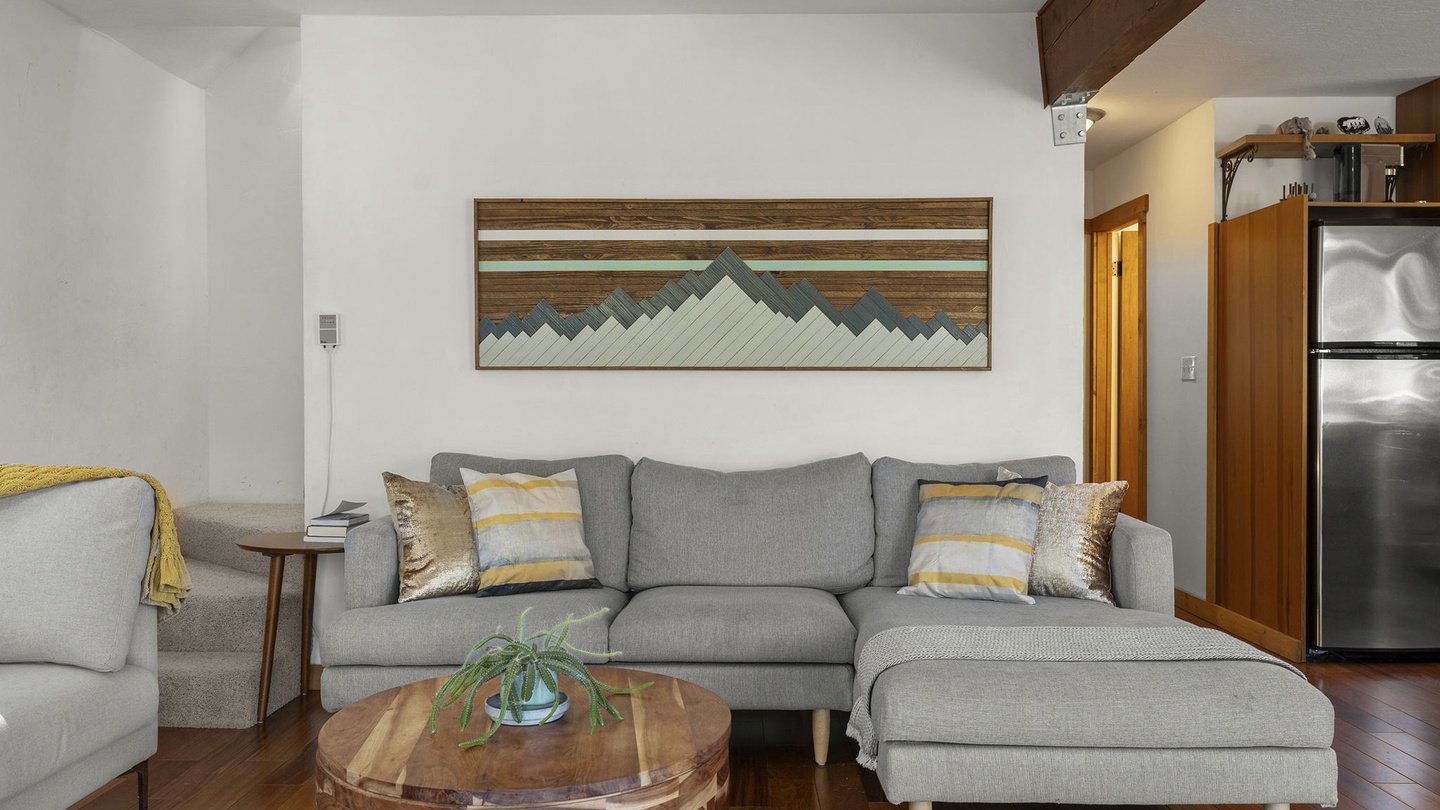 Relax on plush gray sofas while mountain art and warm wood beams create your perfect cozy retreat.