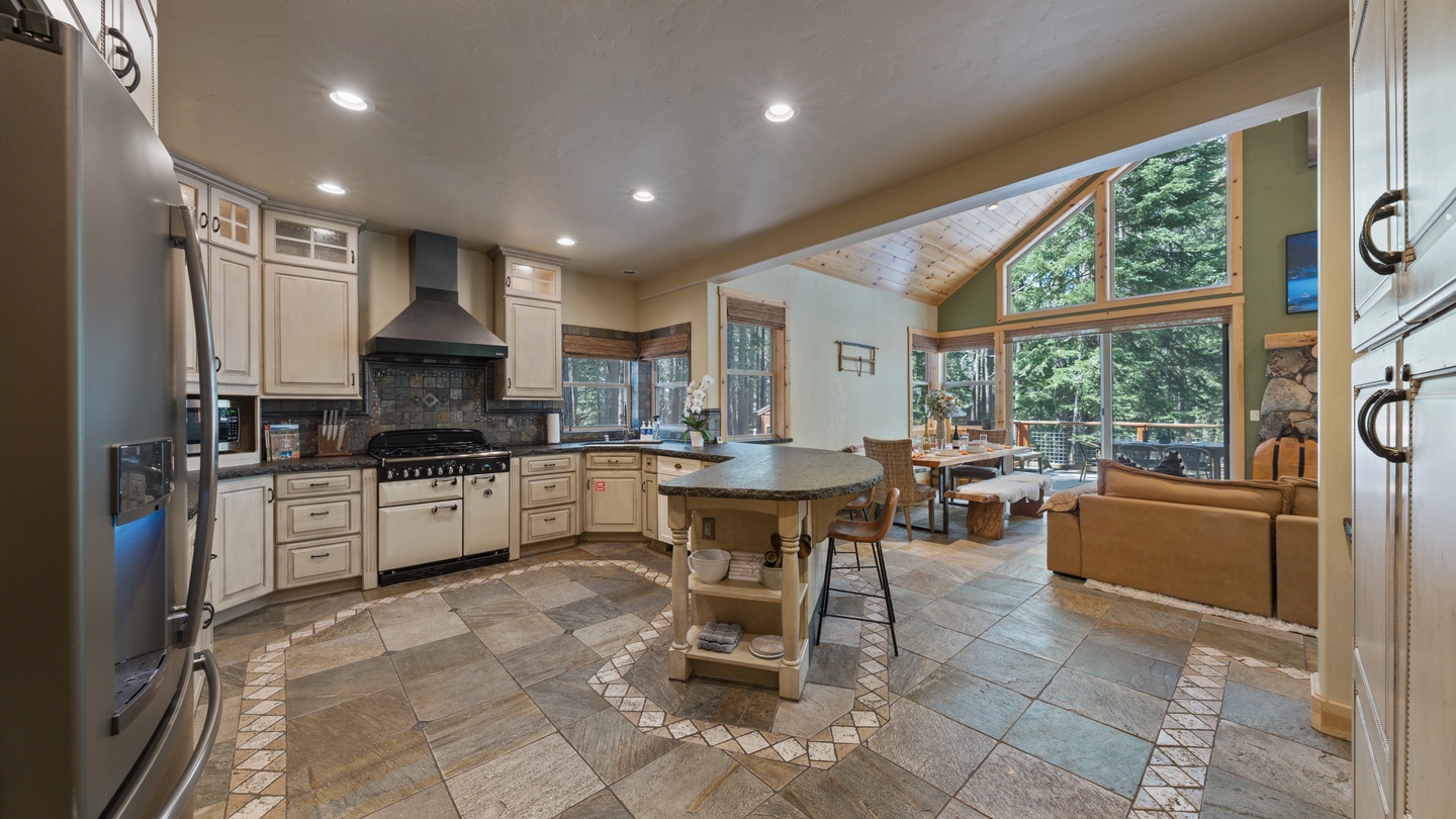Step into your dream mountain retreat, where a spacious gourmet kitchen flows seamlessly into a sunlit living area with soaring windows that frame stunning forest views.