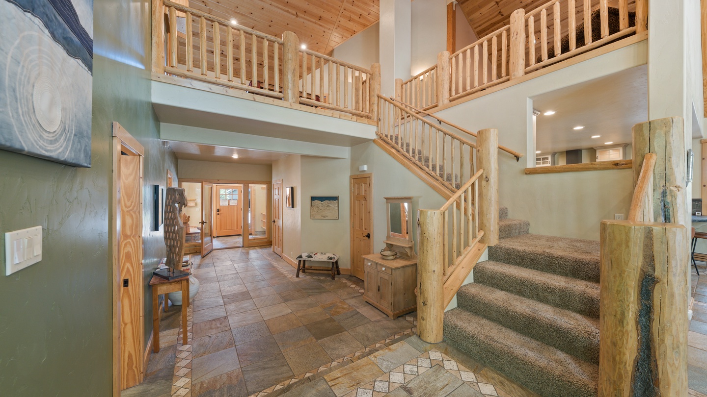 Step into your mountain retreat where soaring ceilings and handcrafted timber railings create an inviting, open atmosphere. The warm wood tones and spacious design make you feel right at home.