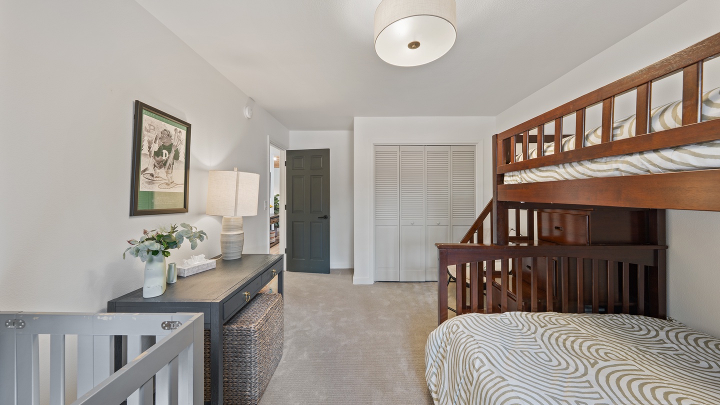A cozy room with a bunk bed configuration perfect for families, offering a full bed below and a twin above. The neutral tones and warm wood create a comfortable retreat for your group.