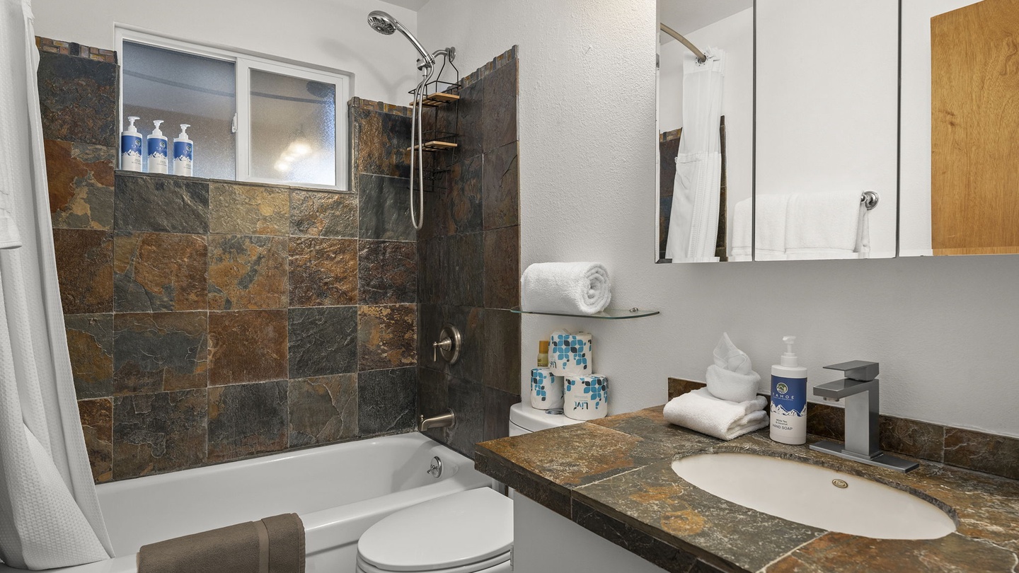 Your private bathroom features beautiful slate tile, a relaxing soaking tub, and all the amenities you need for a refreshing stay.