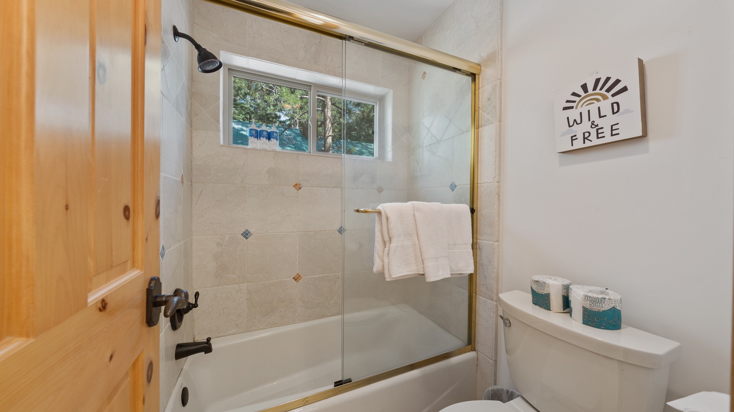 Refresh after your adventures in this bright bathroom, featuring a tub-shower combo and warm wood accents that bring a cozy cabin feel to your daily routine.