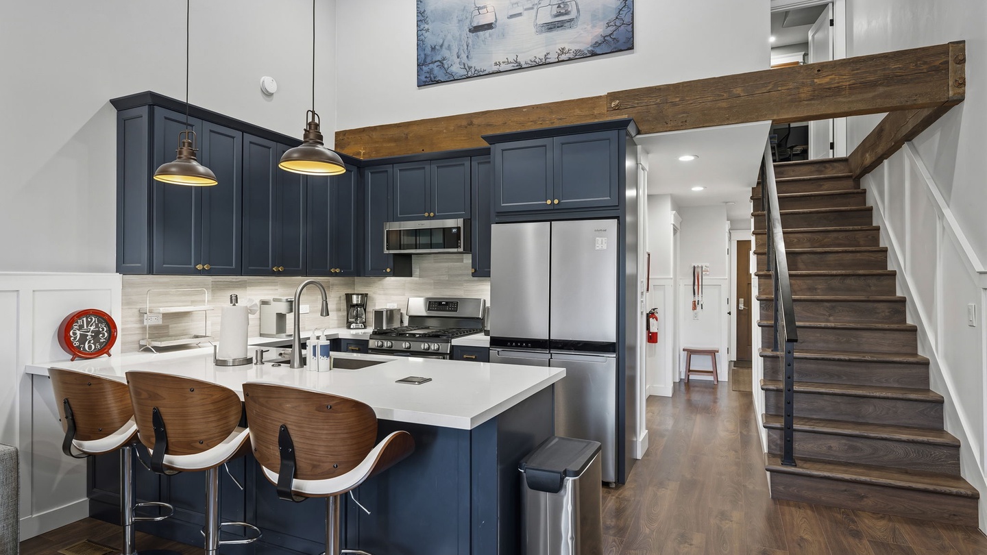 Your stylish kitchen features navy cabinets, white quartz counters, and a breakfast bar perfect for morning coffee or evening wine.