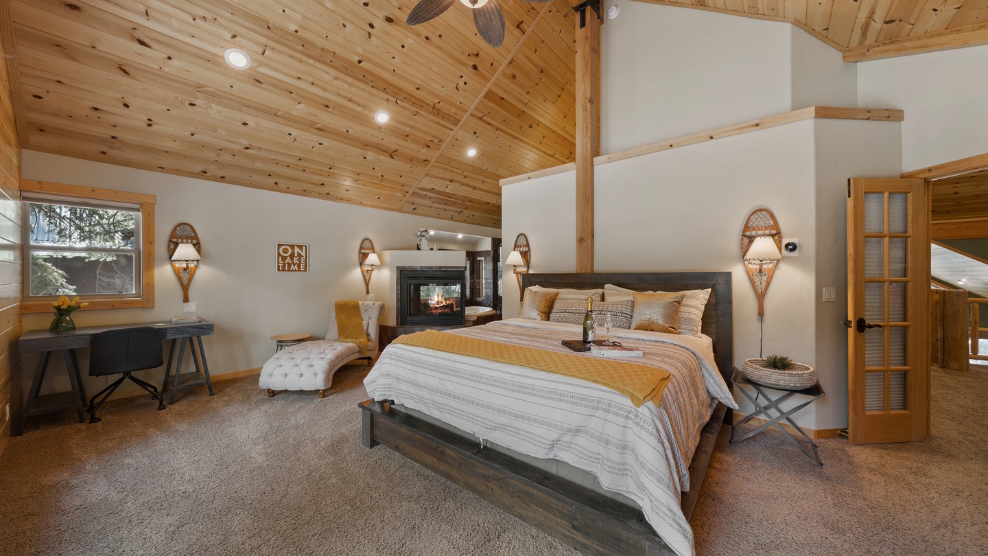 Retreat to your peaceful bedroom where vaulted wood ceilings, a cozy fireplace, and warm lighting create the perfect sanctuary for unwinding after your mountain adventures.