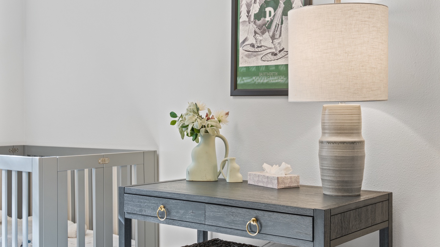 Your peaceful nursery nook features a hand-picked vintage ski poster and soft natural light, creating a calm space to welcome your little one home.