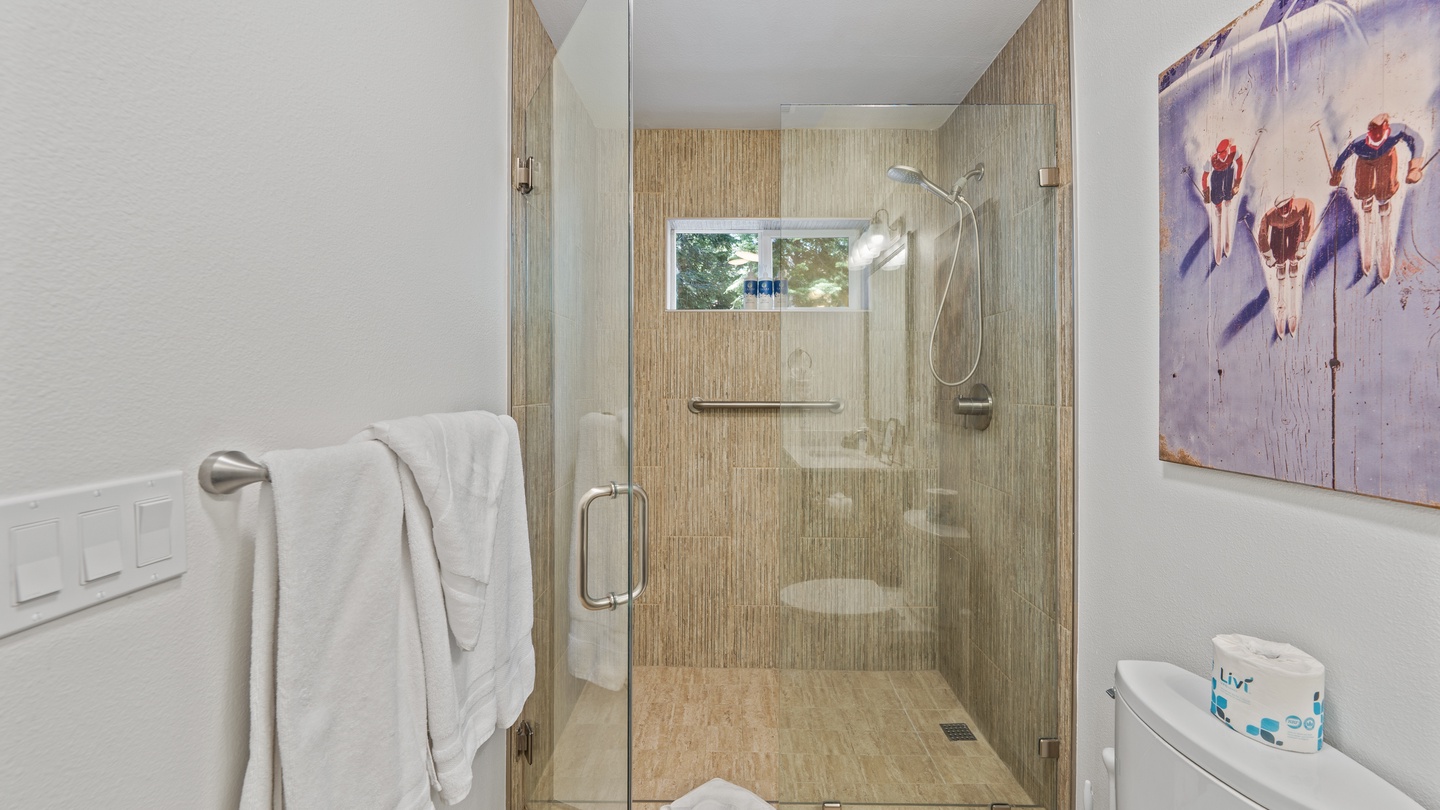 Refresh after your adventures in this bright, modern bathroom with a spacious walk-in shower and warm natural tones that bring a touch of mountain elegance.