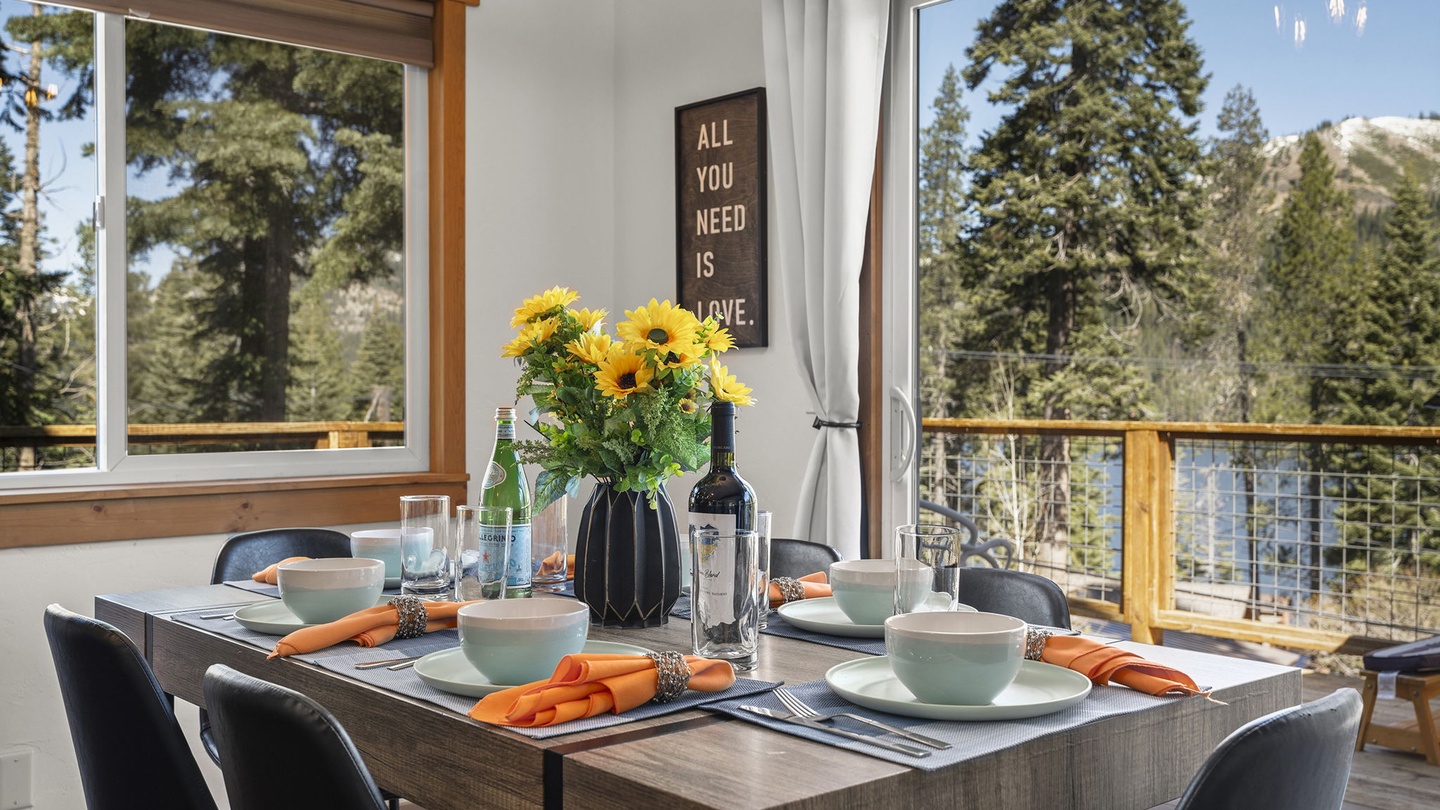Gather around your beautifully set dining table with panoramic lake and forest views streaming through floor-to-ceiling windows, creating the perfect backdrop for memorable meals.