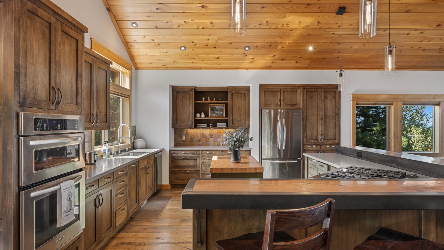 Spacious kitchen with rich wood cabinetry and island seating.