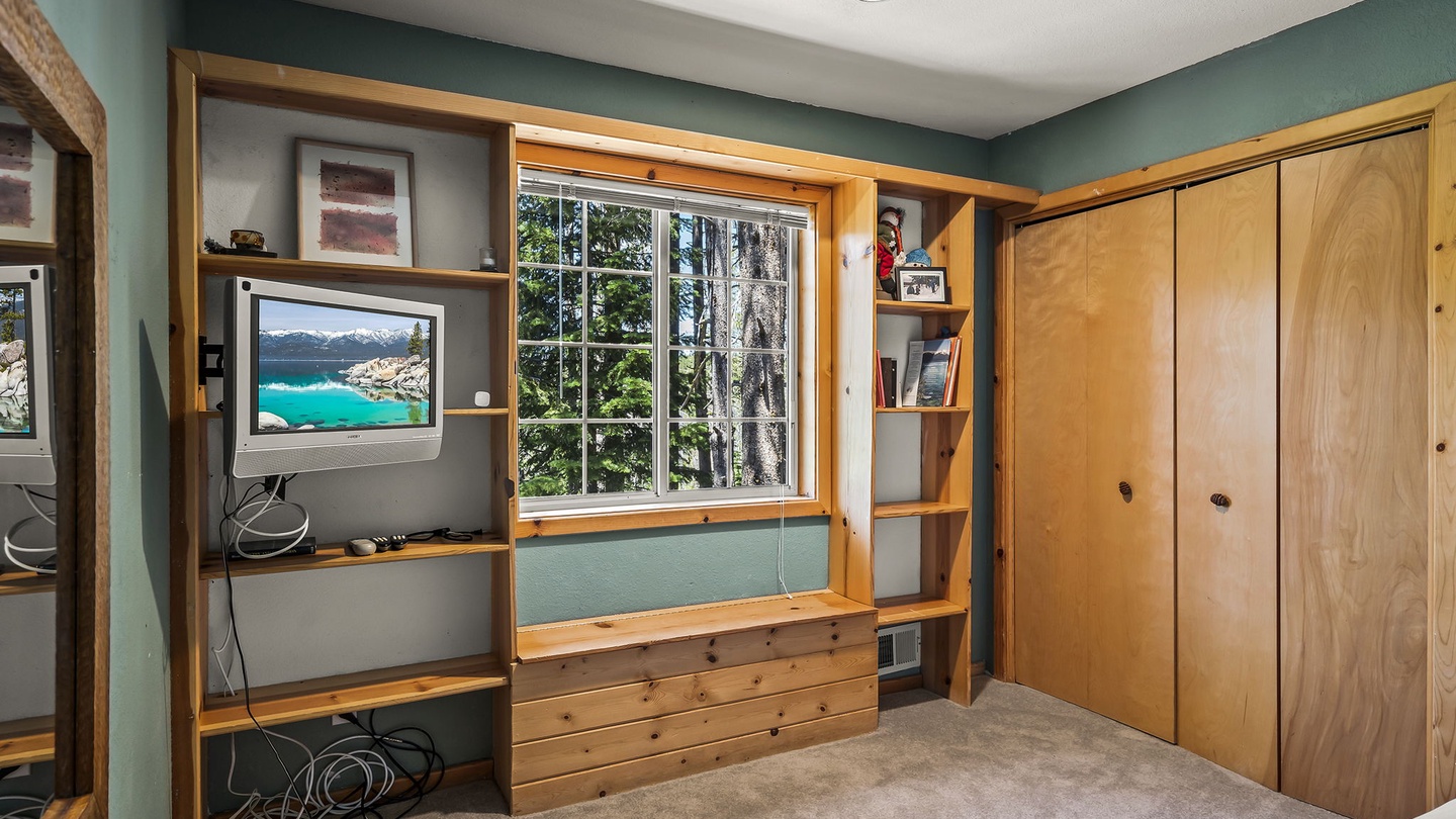 Relax in your cozy retreat with custom wood built-ins, peaceful forest views through the window, and plenty of storage for your getaway essentials.