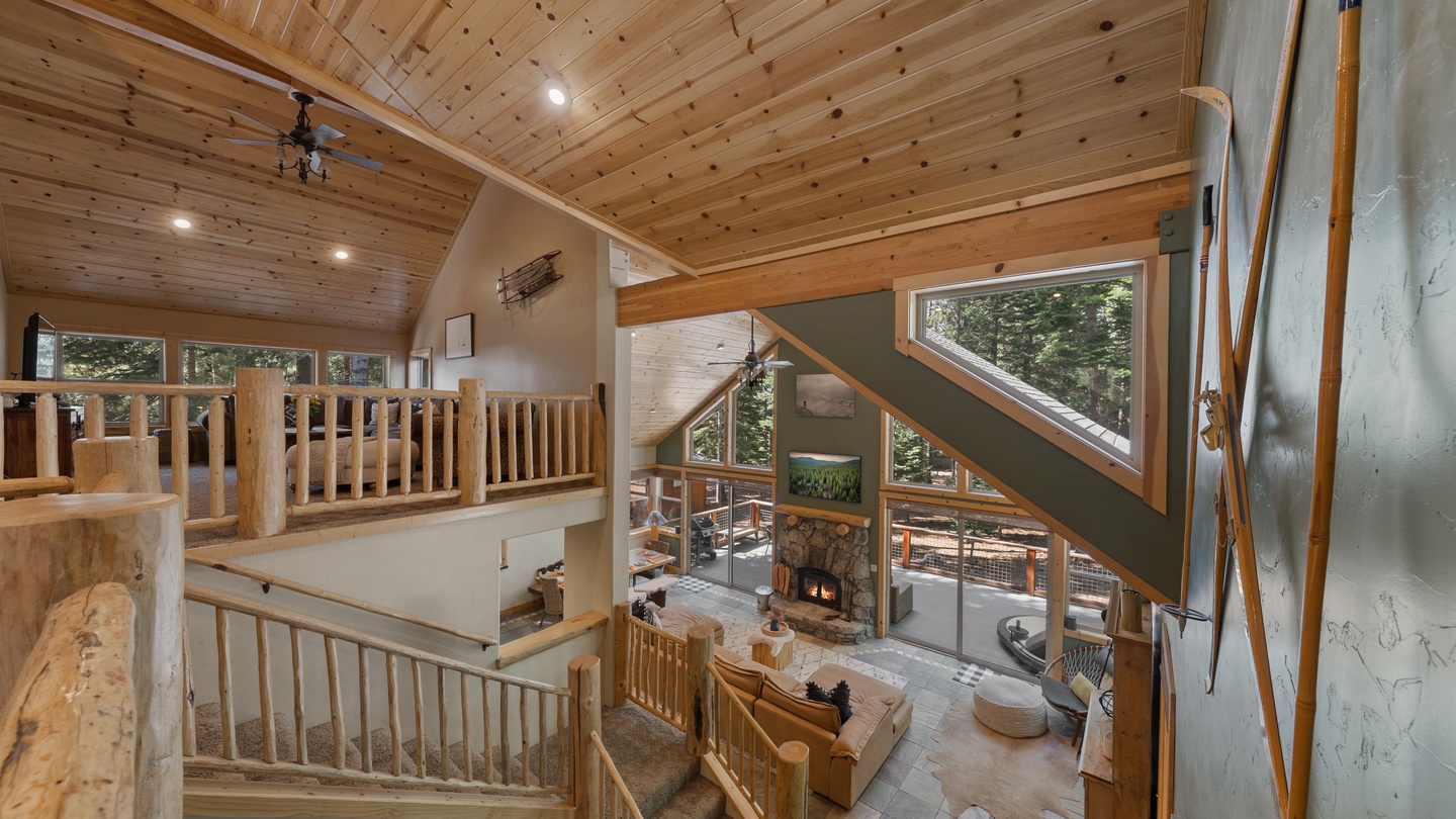 Soaring timber ceilings and expansive windows frame a stunning two-story living space where natural light and mountain forest views surround you. Cozy up by the stone fireplace, then retreat to the loft's peaceful perch above.