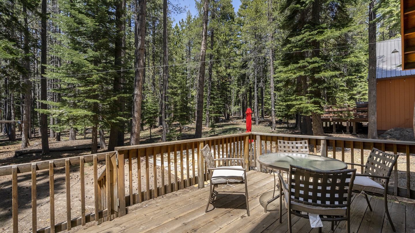 A private forest retreat surrounds this peaceful deck, where towering evergreens frame your mornings. Picture yourself here, breathing in the mountain air and savoring quiet moments at your own outdoor table.