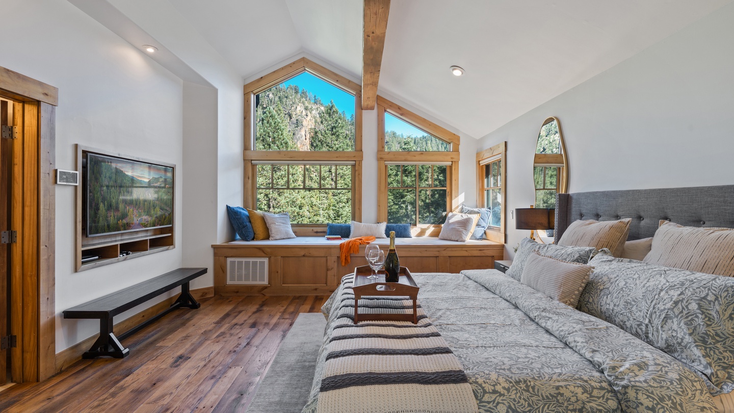 Sink into plush comfort and soak in the stunning mountain views through soaring windows. This inviting living room wraps you in warmth with rustic wood details and soft, layered seating perfect for your mountain retreat.