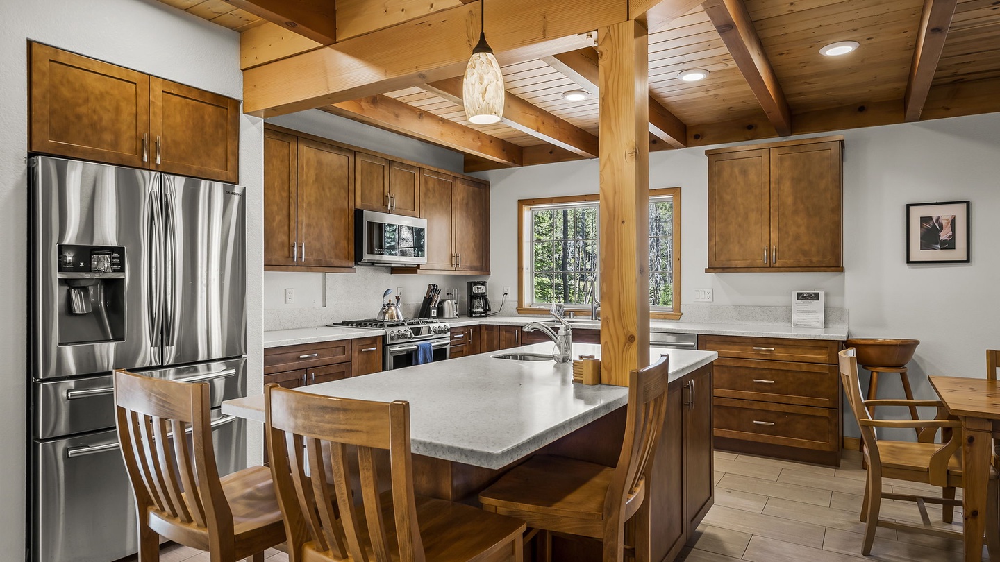 Your mountain retreat's spacious kitchen features warm wood cabinetry, modern appliances, and a large island with seating—perfect for cooking together and sharing stories after a day exploring the trails.