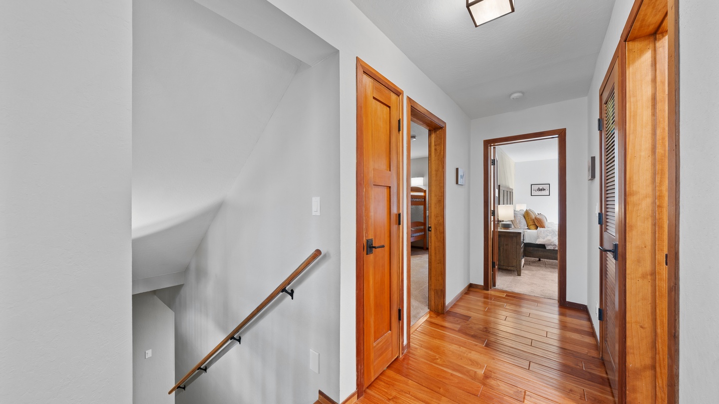 Step into your private upstairs hallway, where rich hardwood floors and warm wood trim create an inviting path to your restful bedrooms and private bath.