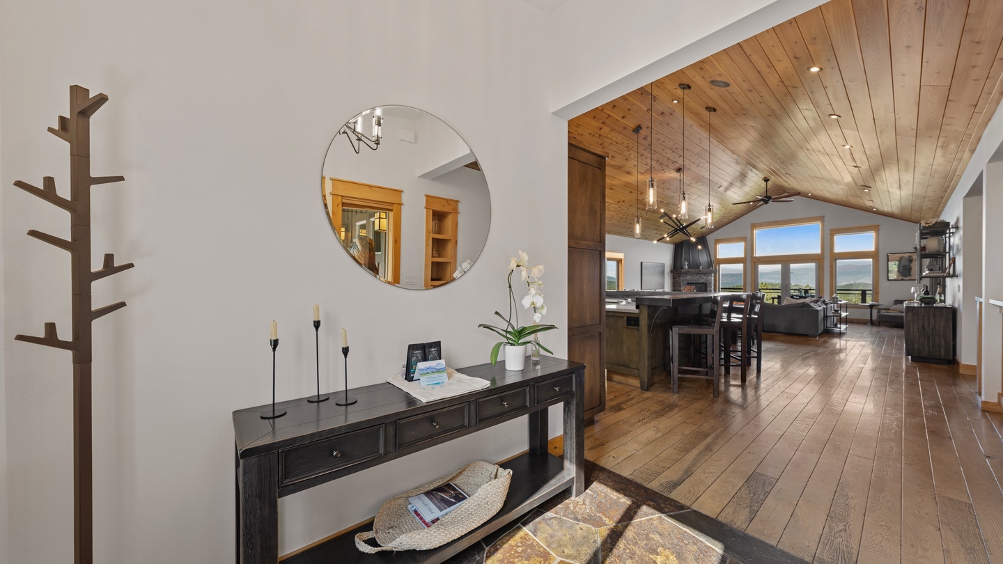 Step into a bright, open space with soaring vaulted ceilings and warm wood floors that stretch throughout. The elegant entryway flows seamlessly into the heart of the home, where natural light pours in.