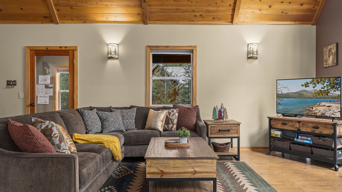 Cozy up in your rustic living room with exposed wood ceilings, plush sectional seating, and mountain views through every window.