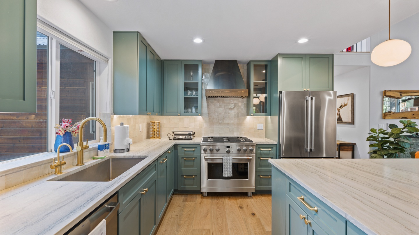 Your chef-ready kitchen features sage-green cabinetry, gleaming countertops, and professional-grade appliances, making every meal a joy to prepare during your stay.