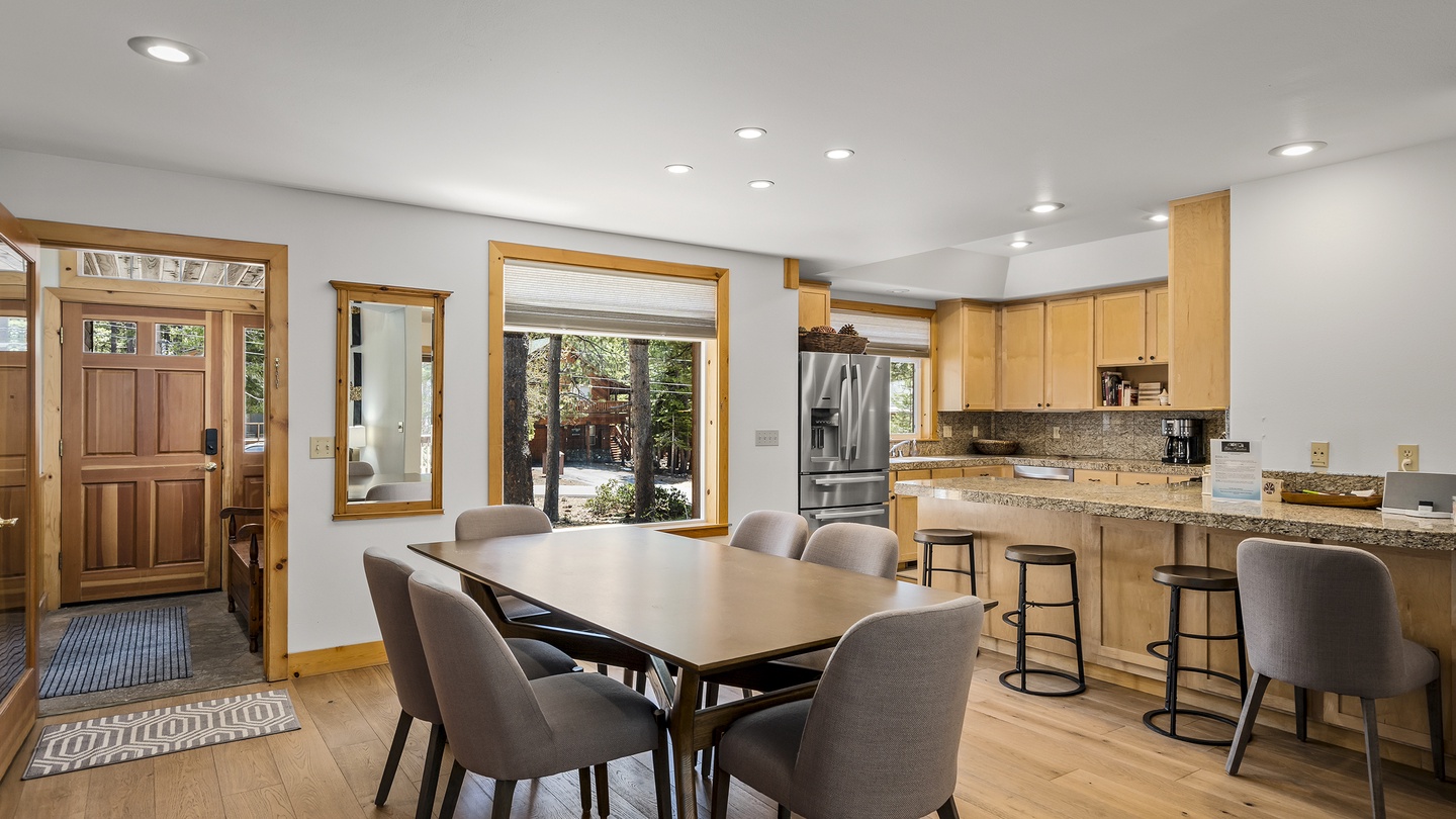 Gather around the table in this open kitchen and dining space, where natural light pours through large windows. Modern appliances and a breakfast bar make meal prep easy and social.