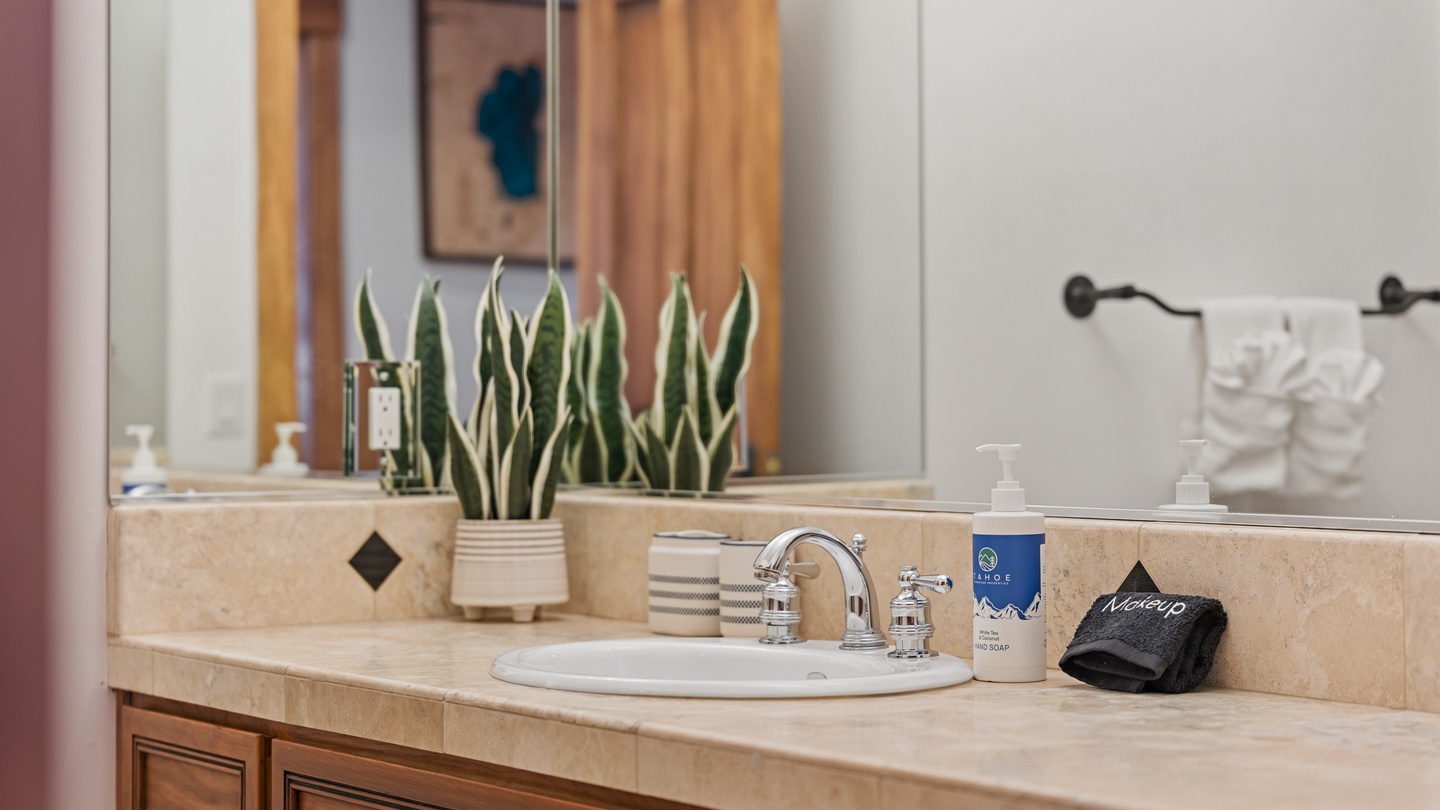 Your bathroom features elegant stone countertops, thoughtful greenery, and fresh towels waiting to welcome you after a long day of exploring.