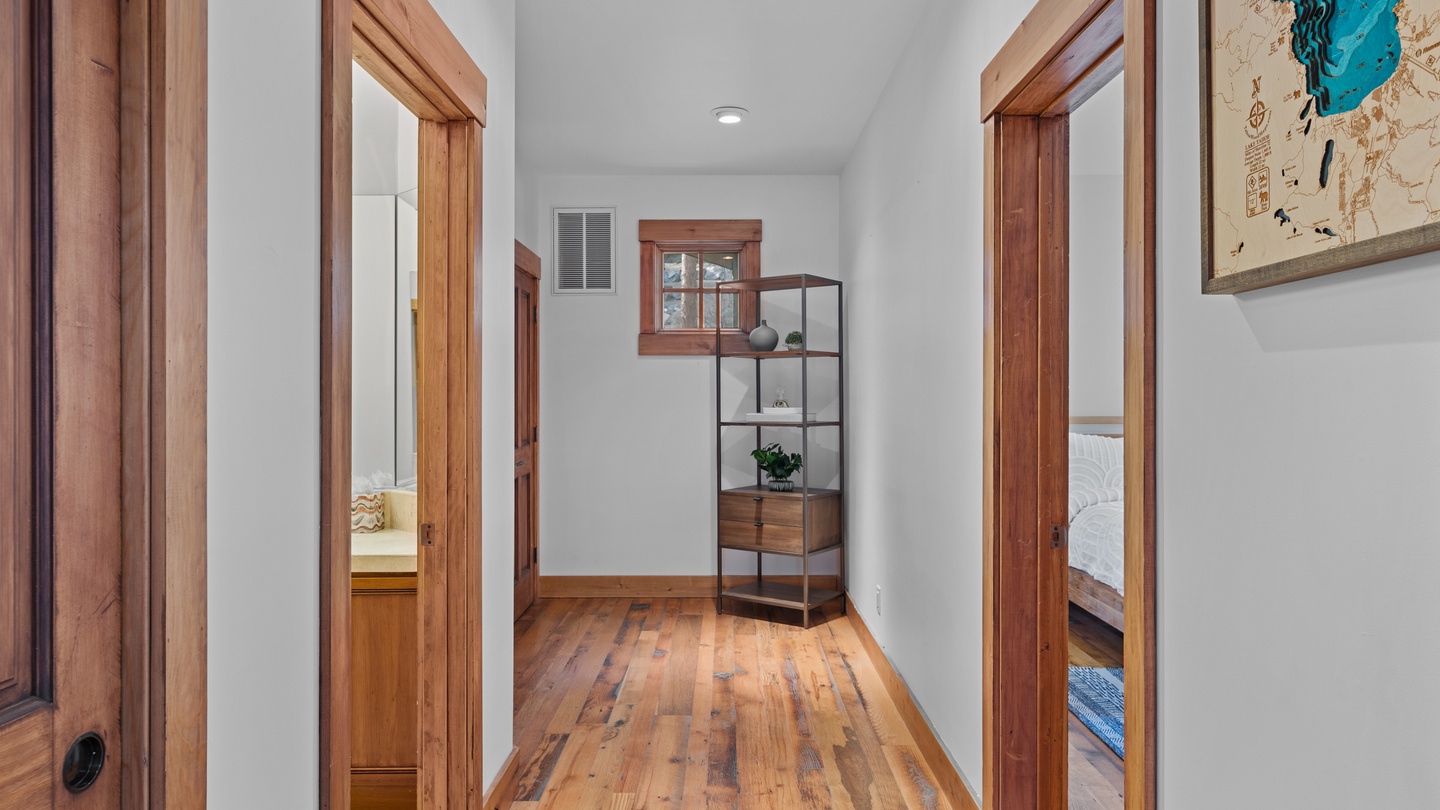 Step into your private hallway where warm wood tones and soft natural light create a welcoming transition between bedrooms. Each door opens to a peaceful retreat designed just for you.