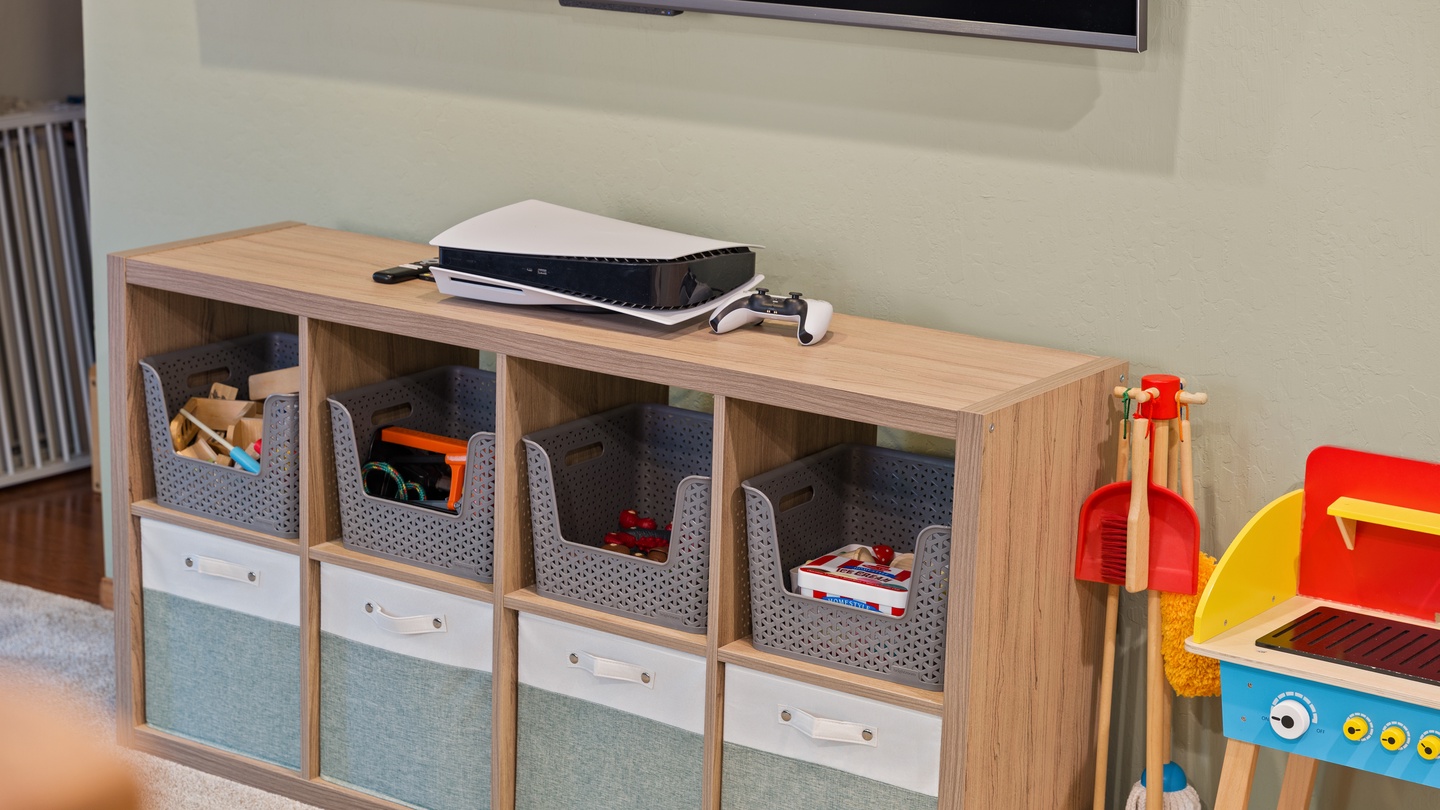 Your little ones can play to their hearts' content with neatly organized storage baskets and a well-appointed entertainment setup featuring a gaming console and large TV.