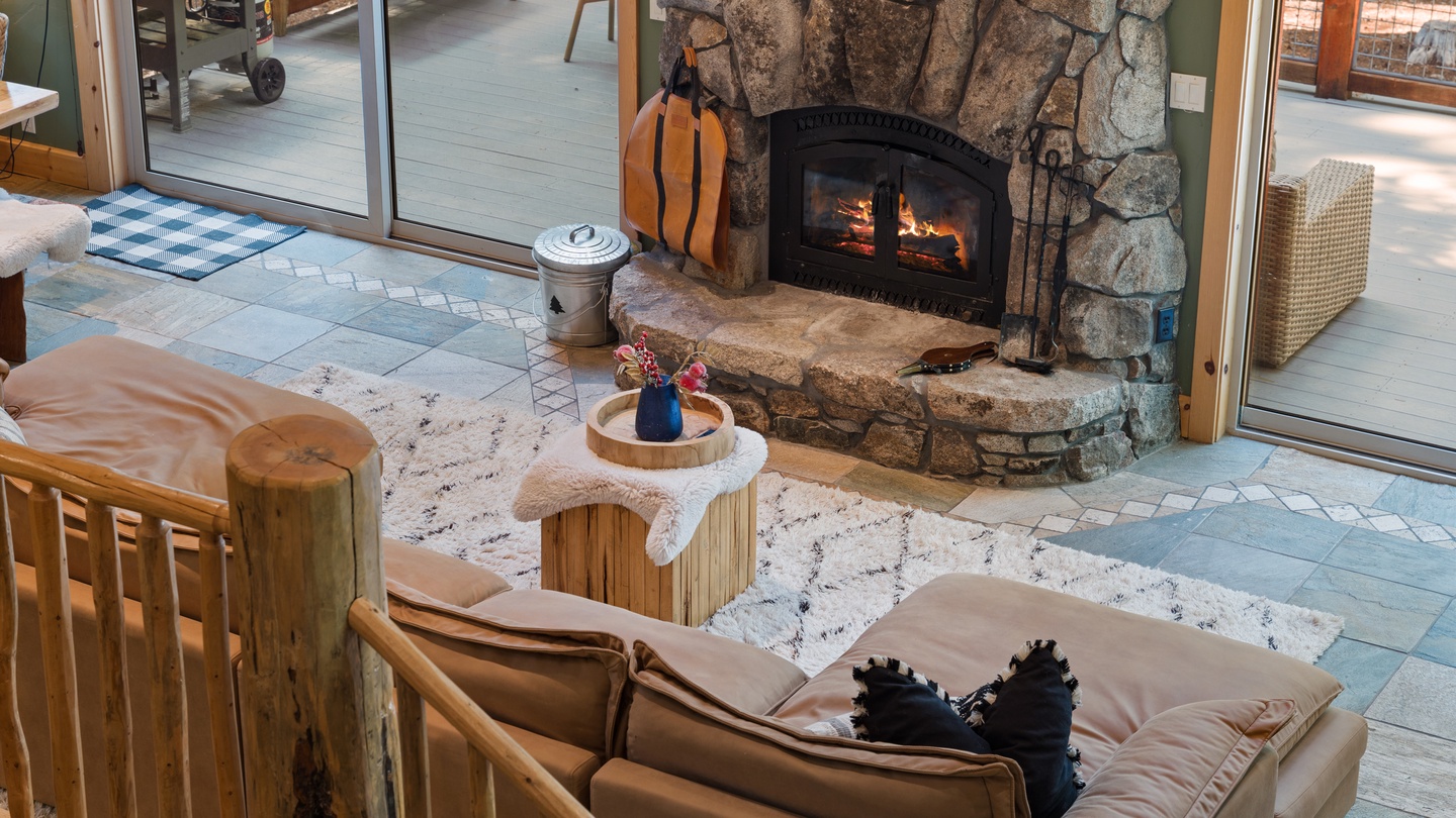 Cozy up by your stone fireplace with flickering flames casting warm light across the living room. The rustic charm and comfortable seating invite you to unwind after a day of mountain adventures.