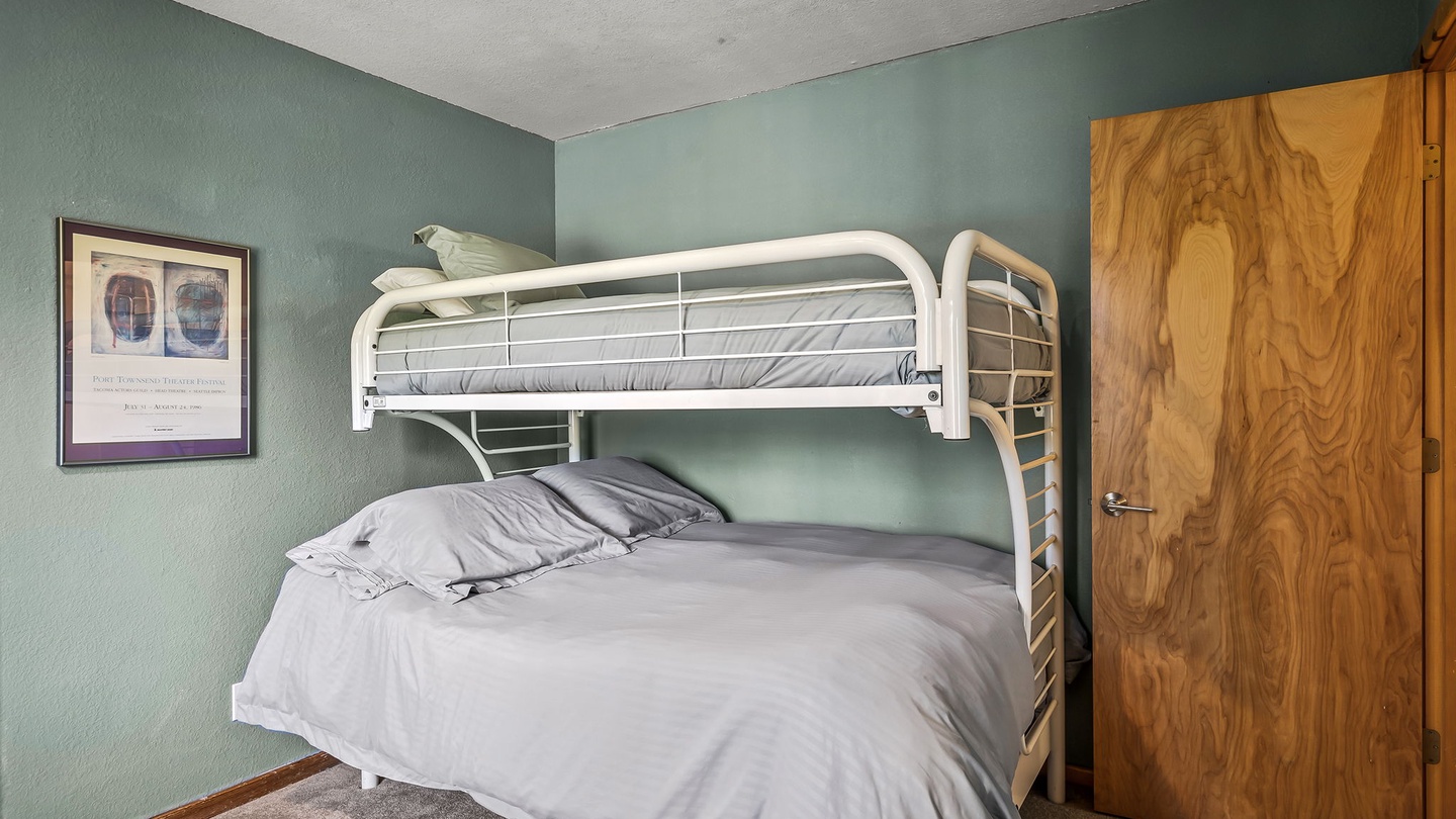 Perfect for families or groups, this bunk bed setup offers comfortable sleeping arrangements with space-saving efficiency. The calming sage walls and natural wood accents create a peaceful retreat for rest after your day's adventures.