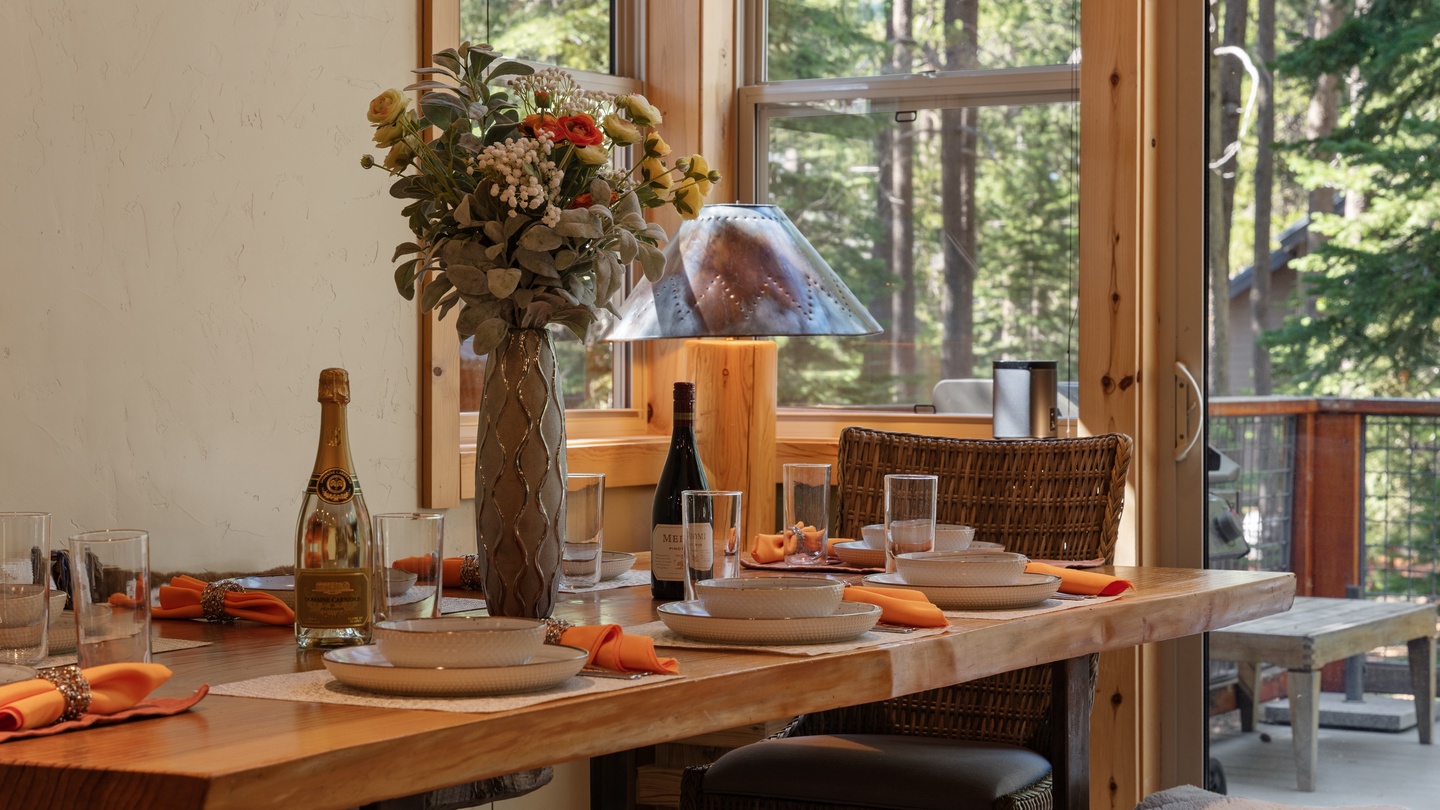 Gather around your beautifully set dining table where forest views through floor-to-ceiling windows create the perfect backdrop for memorable meals together.
