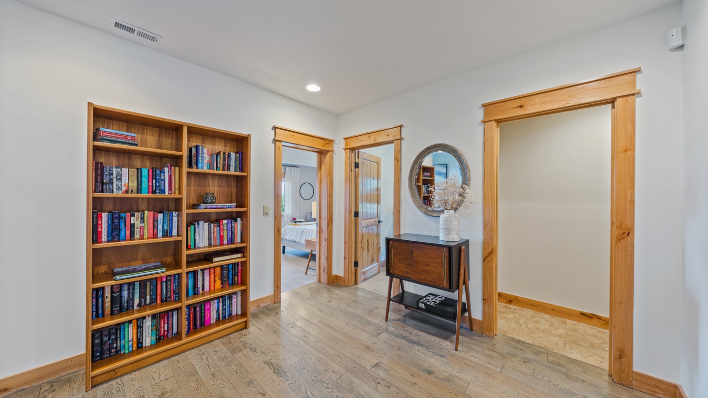 Step into a serene hallway where warm wood accents meet clean, modern design. Your personal library awaits, while natural light filters through private spaces beyond.