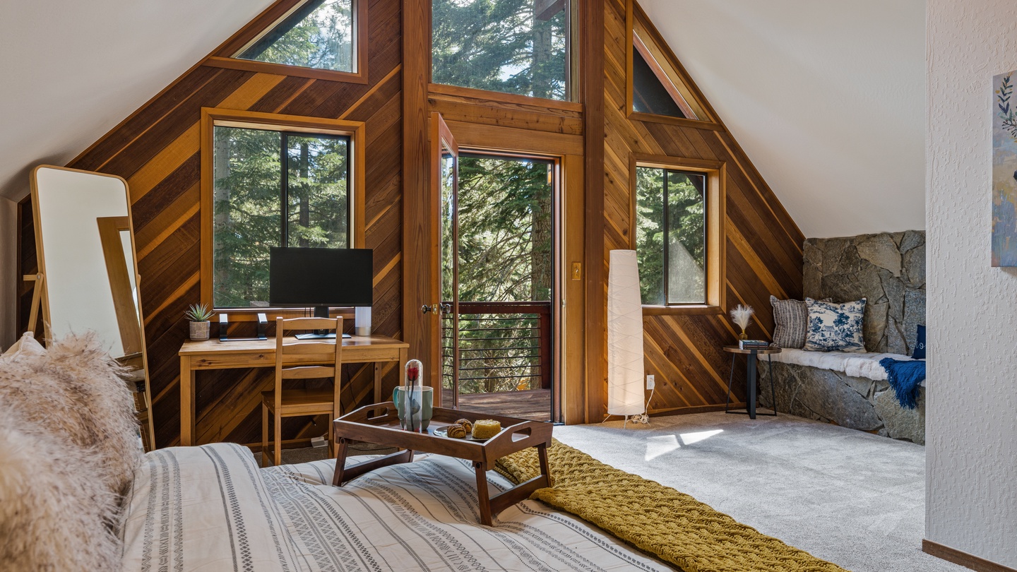 Step into your cozy A-frame sanctuary where tall windows frame breathtaking forest views. Sunlight streams through the glass, highlighting warm wood tones and inviting you to unwind in this serene mountain escape.