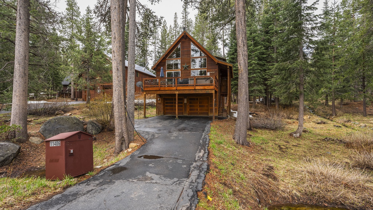 A beautiful mountain cabin nestled among towering pines offers the perfect forest retreat with convenient driveway parking.