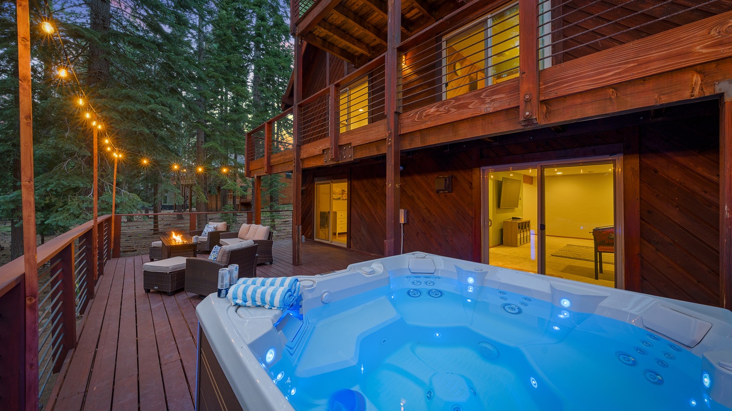 Slip into your private hot tub under the string lights, then warm up by the fire pit on your spacious deck surrounded by towering pines—your perfect mountain retreat awaits.